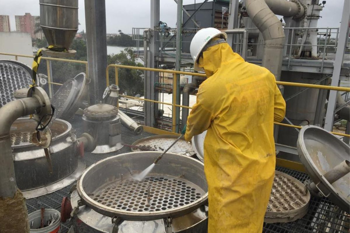 Profissional realizando limpeza técnica em ambiente industrial