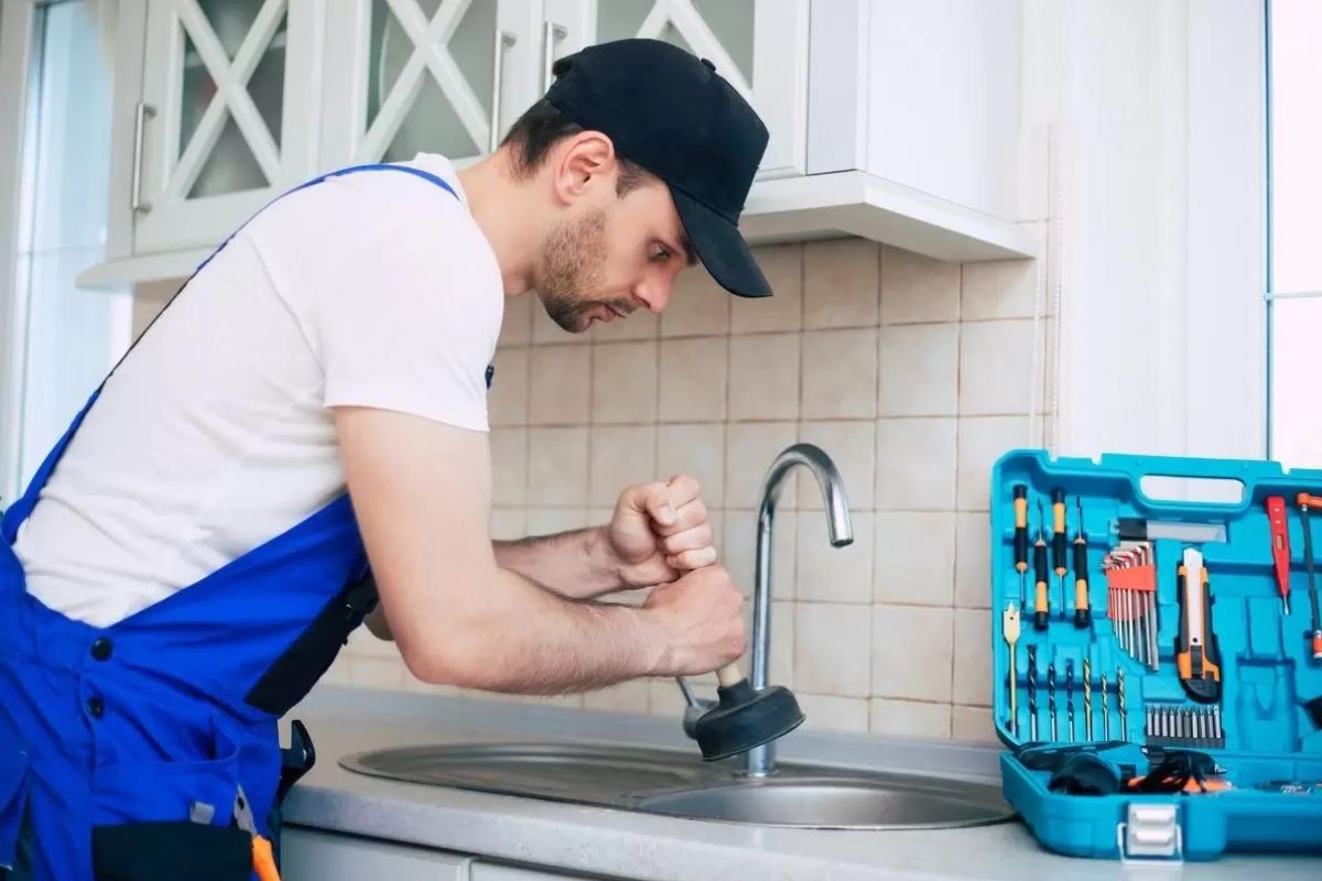 Profissional utilizando equipamento para desentupir pia da cozinha