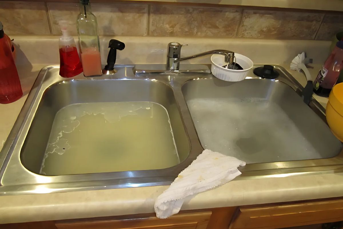 Pia da cozinha com água acumulada devido a entupimento