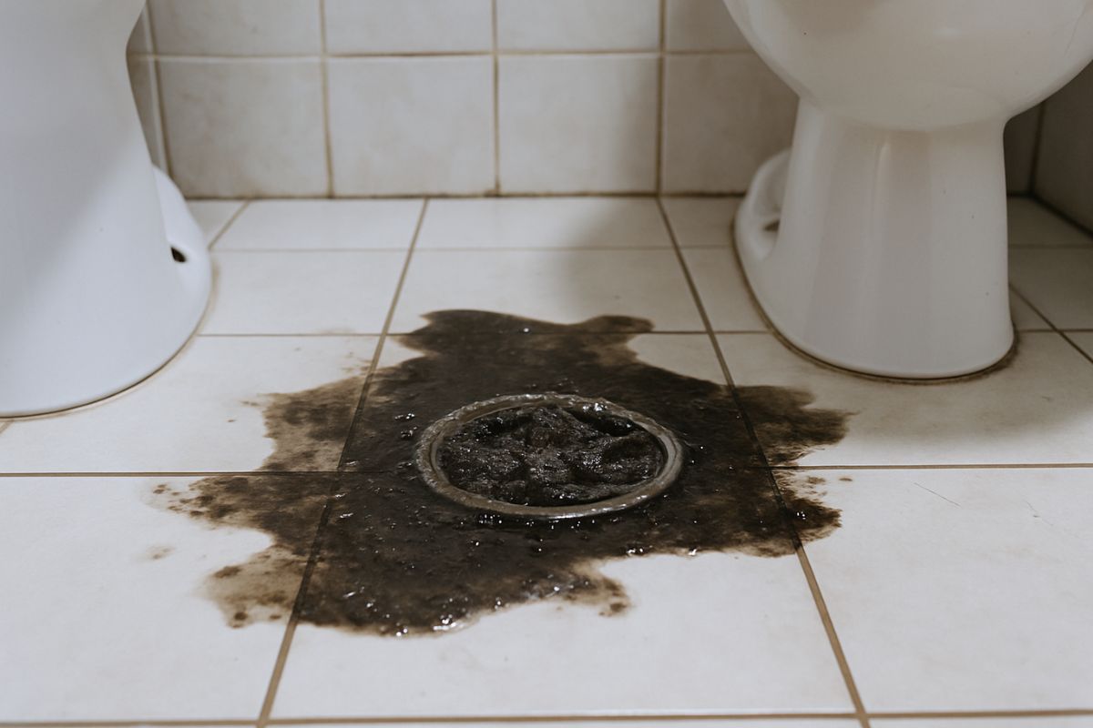 Água de esgoto retornando pelo ralo de banheiro durante entupimento